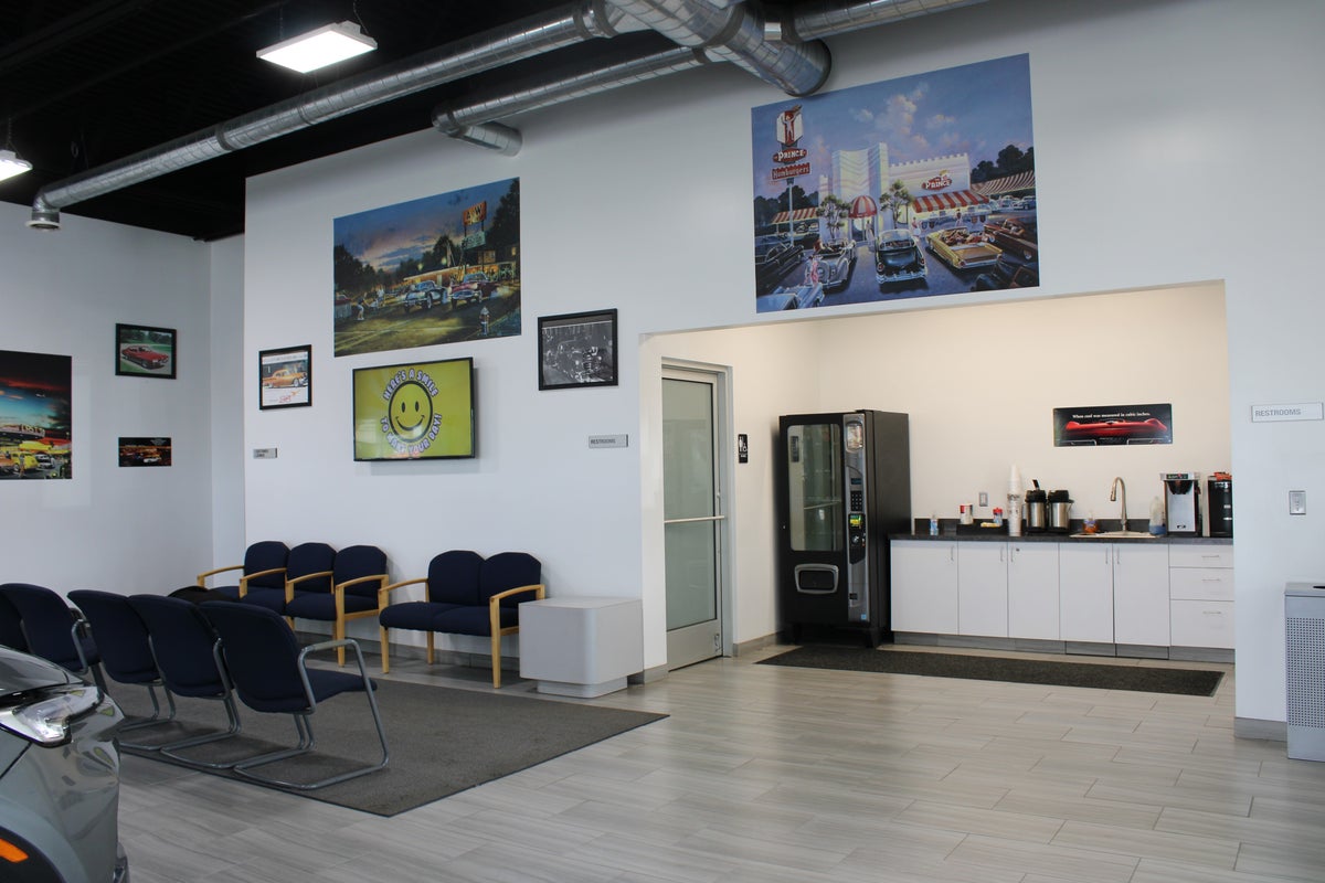 Auto dealership lounge area with customer seating and refreshment counter